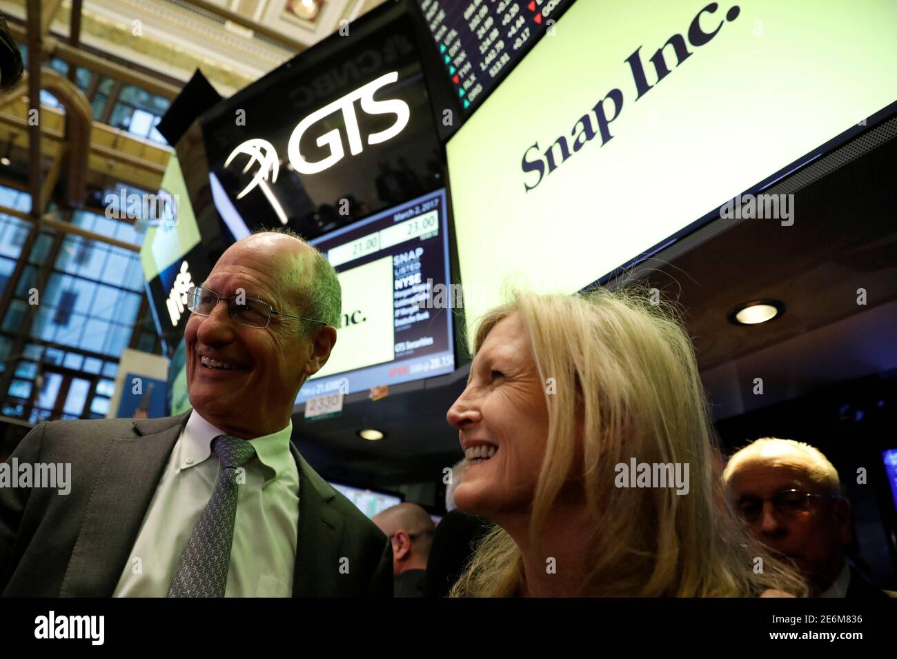 Snap co-founder Evan Spiegel's parents, John Spiegel and Melissa Thomas  stand on the floor of the New York Stock Exchange (NYSE) while waiting for  Snap Inc. to list their IPO in New