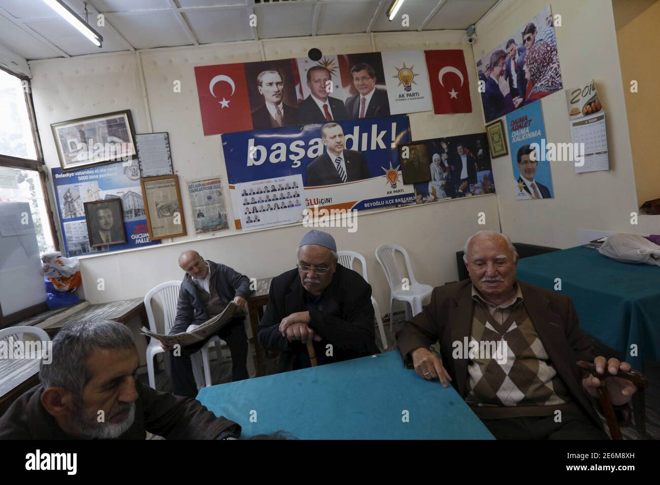 Men chat at a local election campaign office of the ruling AK Party in Istanbul, Turkey, October 30, 2015. Turkey holds its second general election of the year on Nov. 1, a snap vote which President Tayyip Erdogan hopes will see the ruling AK Party win back the majority it lost five months ago. In the background (L-R) posters of Turkey's founding leader Ataturk, President Tayyip Erdogan and Prime Minister Ahmet Davutoglu are seen. REUTERS/Murad Sezer Stock Photo