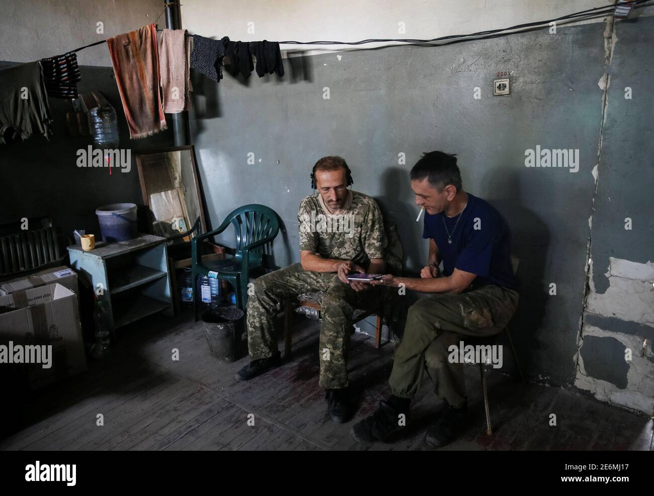 Ukrainian servicemen use a mobile device as they rest at their position on the front line near Avdeyevka, Ukraine, August 10, 2016. Picture taken August 10, 2016. To match story UKRAINE-CRISIS/INFORMATION-WAR REUTERS/Gleb Garanich Stock Photo