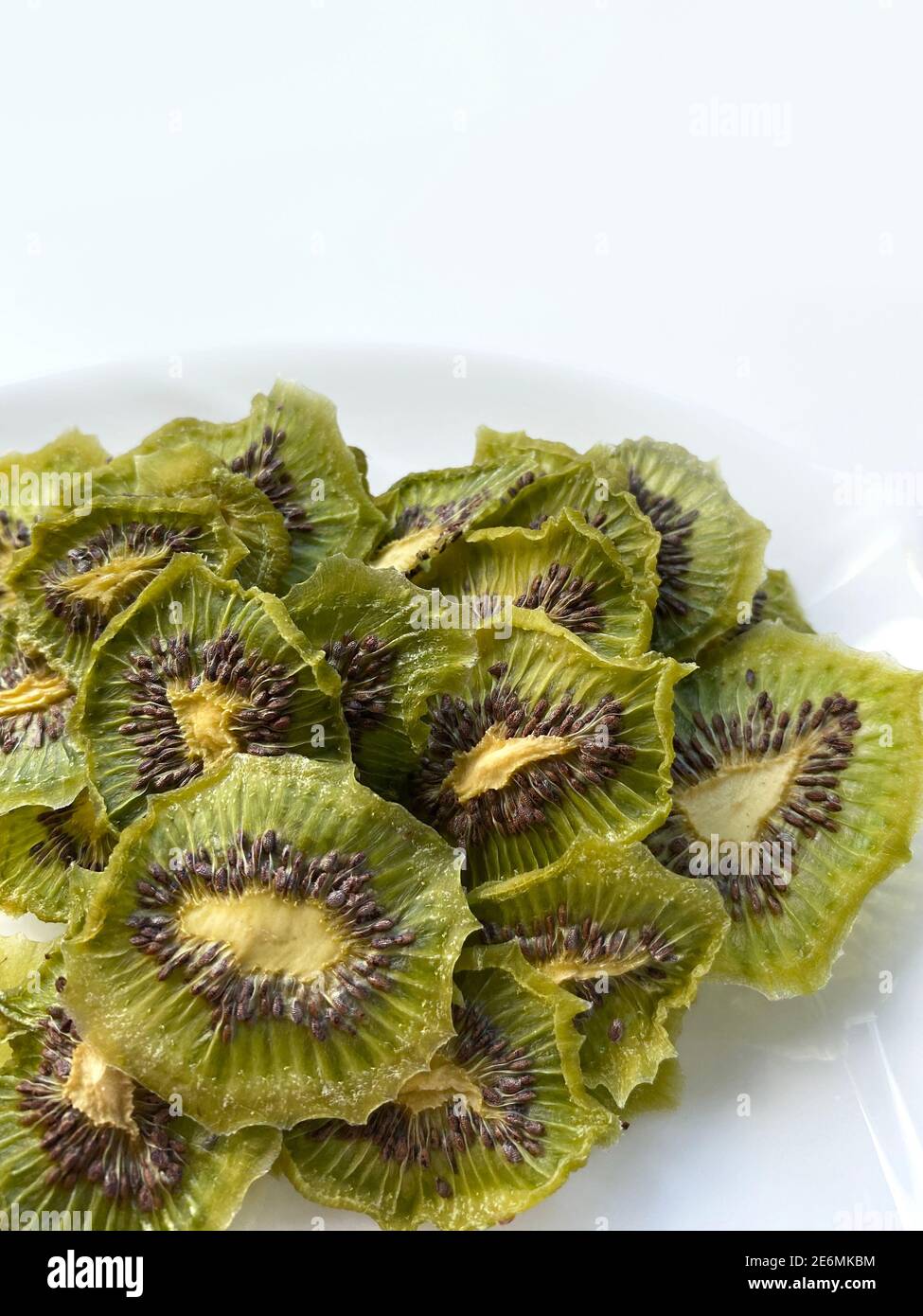 Dehydrated kiwi slices with sugar isolated on white plate Stock Photo