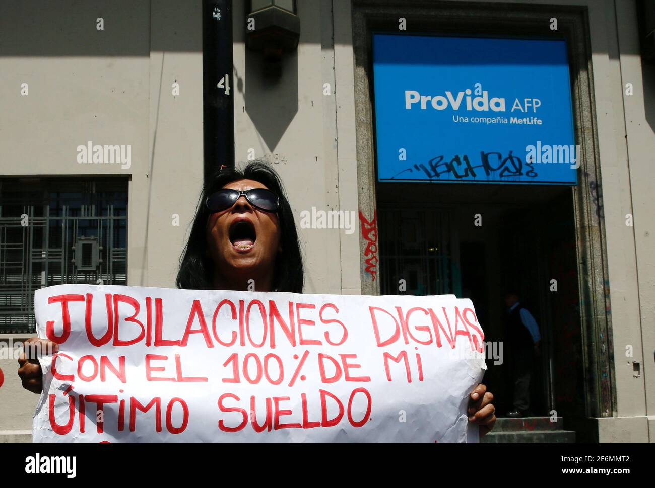 A demonstrator shouts slogans against the national pension system with a placard that reads: 'Decent pensions with 100% of my last salary' in front of an administrator of pensions with the name of Provida-AFP, during a strike in Valparaiso, Chile November 4, 2016. REUTERS/Rodrigo Garrido Stock Photo