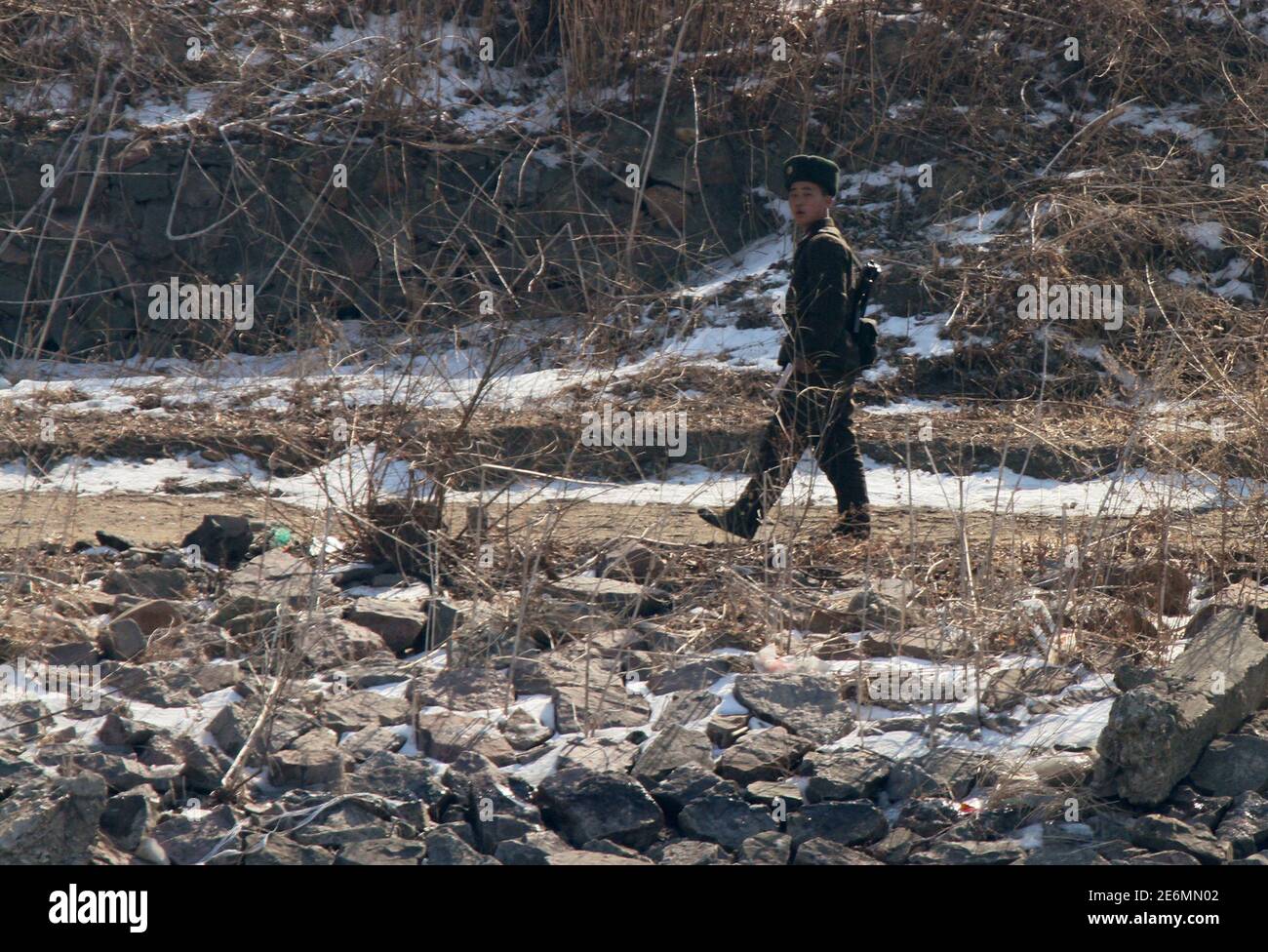 A soldier patrols on the banks of the Yalu River, near the North Korean town of Sinuiju, opposite the Chinese border city of Dandong, February 26, 2016. Picture taken from China's side of the Yalu. REUTERS/Jacky Chen Stock Photo