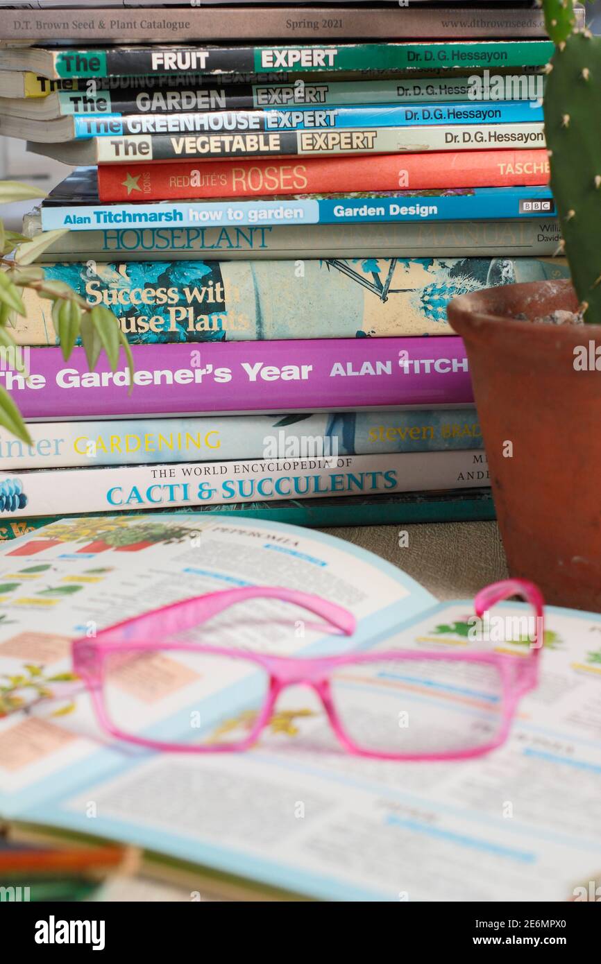 Gardening books. UK. Gardeners glasses on a stack of her gardening books. Stock Photo