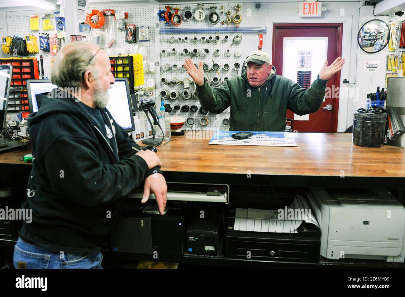 TAN Trucking company owner Ted Nelson (R) talks to J&C Custom Trucking parts manager Gary Bliss about the challenge of running an oil field company during a slowdown caused by low oil prices in Watford City, North Dakota January 21, 2016. Persistent low oil prices have lead to slower business in much of North Dakota's Bakken oil fields. J&C Custom Trucking has decreased its staff from six mechanics to three, and sometimes still doesn't have enough work to keep them busy.  The collapse of U.S. oil and gas investment could have further to fall and Americans are showing signs they spend less of t Stock Photo