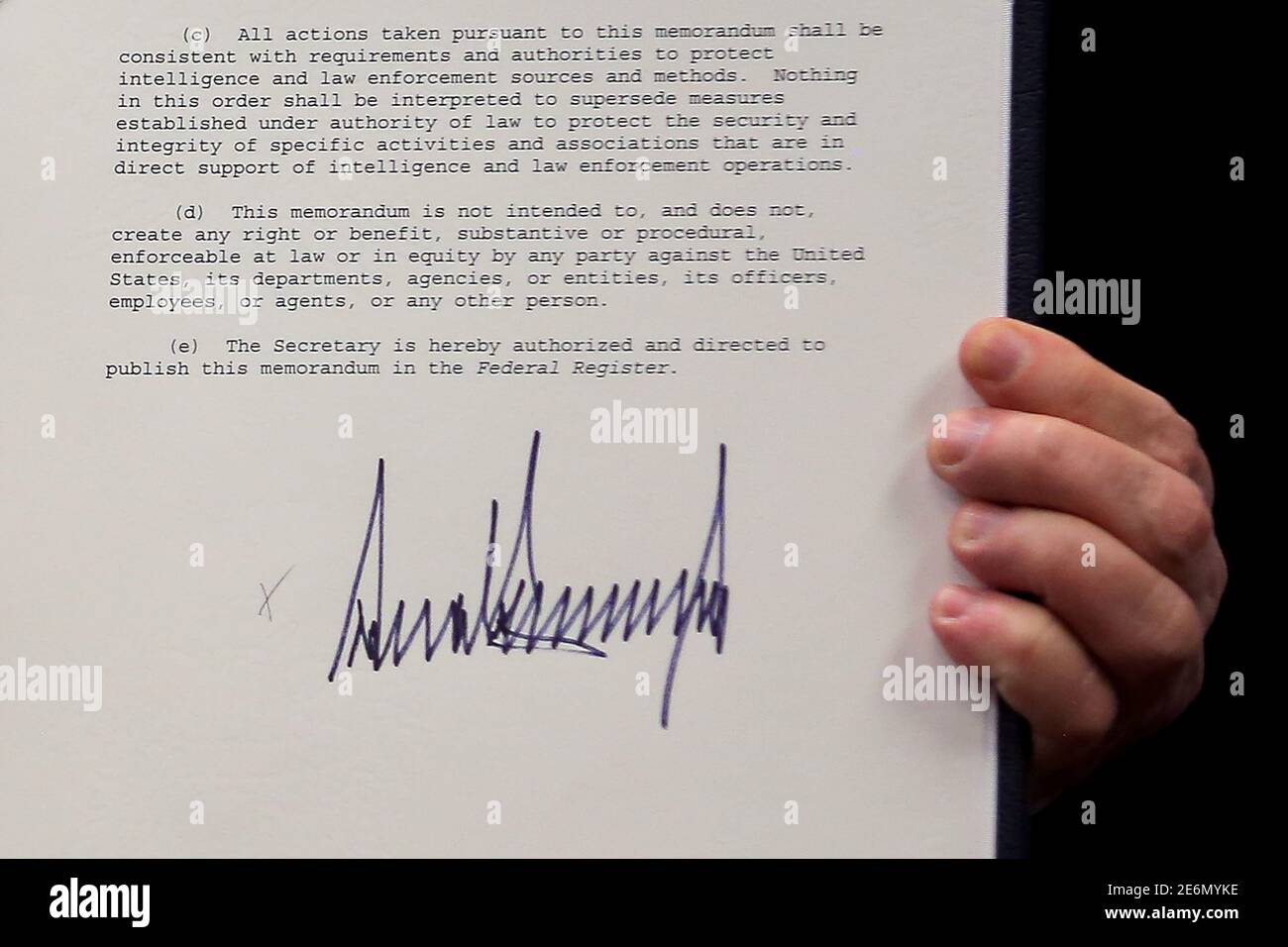 U.S. President Donald Trump shows an executive action he said would begin the rebuilding of the U.S. military by 'developing a plan for new planes, new ships, new resources and new tools for our men and women in uniform' after signing it, at the Pentagon in Washington, U.S., January 27, 2017. REUTERS/Carlos Barria Stock Photo
