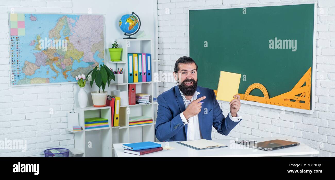 Portrait of happy hipster guy smiling while sitting at desktop with ...