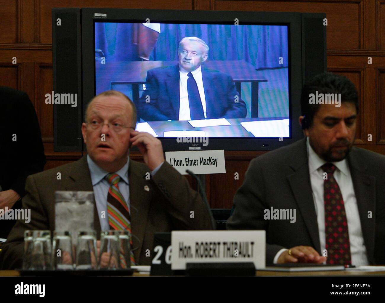 Former Progressive Conservative cabinet minister Elmer MacKay (C) waits to testify via video conference before the Commons ethics committee on Parliament Hill in Ottawa February 25, 2008. The committee is probing former Canadian Prime Minister Brian Mulroney's business dealings with German-Canadian arms dealer Karlheinz Schreiber. Also pictured are Liberal MPs Robert Thibault (L) and Sukh Dhaliwal (R). REUTERS/Chris Wattie (CANADA) Stock Photo
