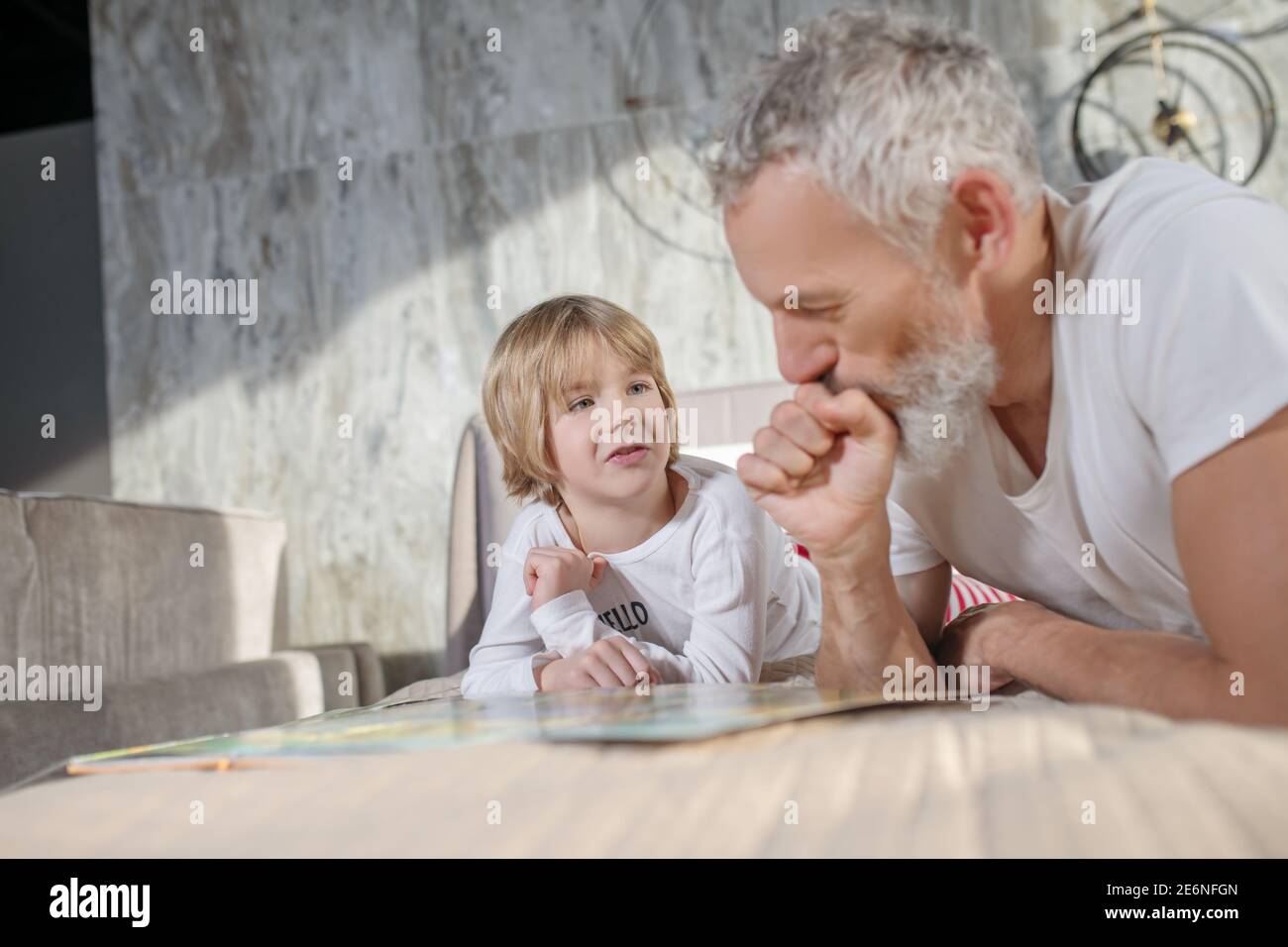 Dad and child at home talking on bed Stock Photo