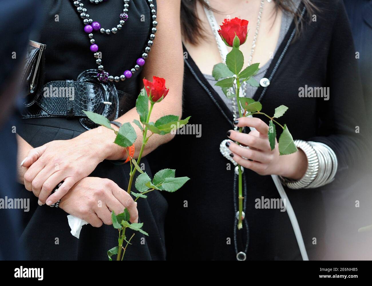 Mourners hold red roses before the funeral of Private Johnathon Young of the 3rd Battalion The Yorkshire Regiment (Duke of Wellington's) at Holy Trinity church in Hull, northern England September 16, 2009.  Private Young died in an explosion while on foot patrol in Helmand province, Afghanistan, on August 20.    REUTERS/Nigel Roddis (BRITAIN OBITUARY CONFLICT) Stock Photo