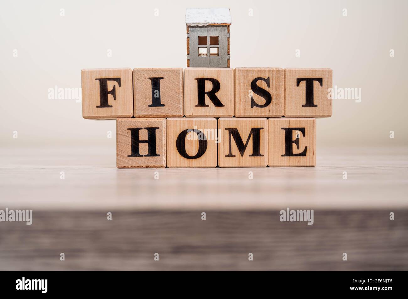 Text FIRST HOME on wood cube blocks isolated on wooden table background ...