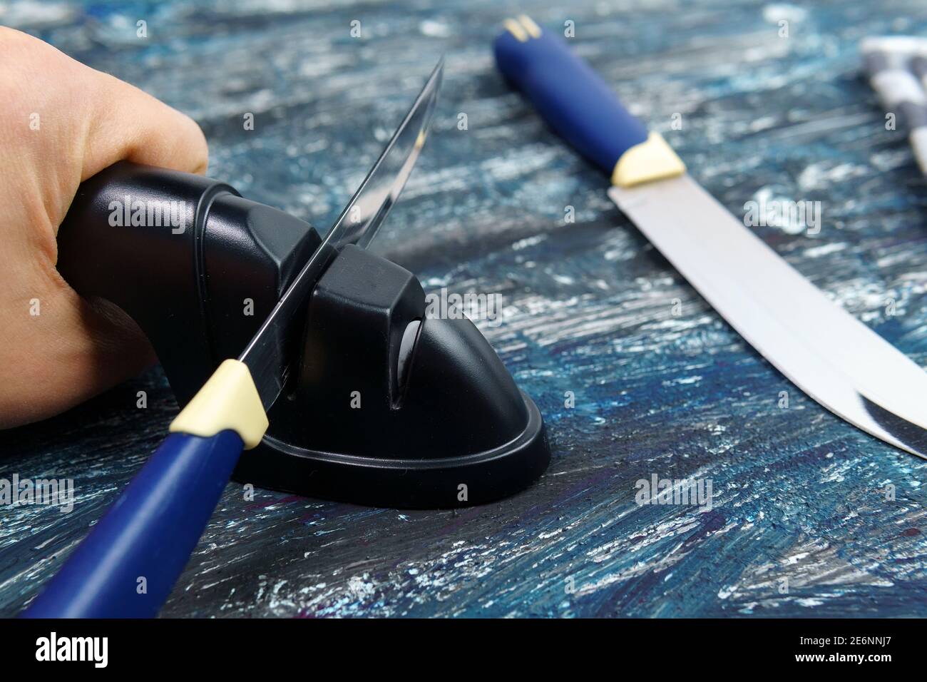 https://c8.alamy.com/comp/2E6NNJ7/sharpening-a-knife-close-up-of-a-man-using-a-sharpener-to-sharpen-a-knife-blade-2E6NNJ7.jpg