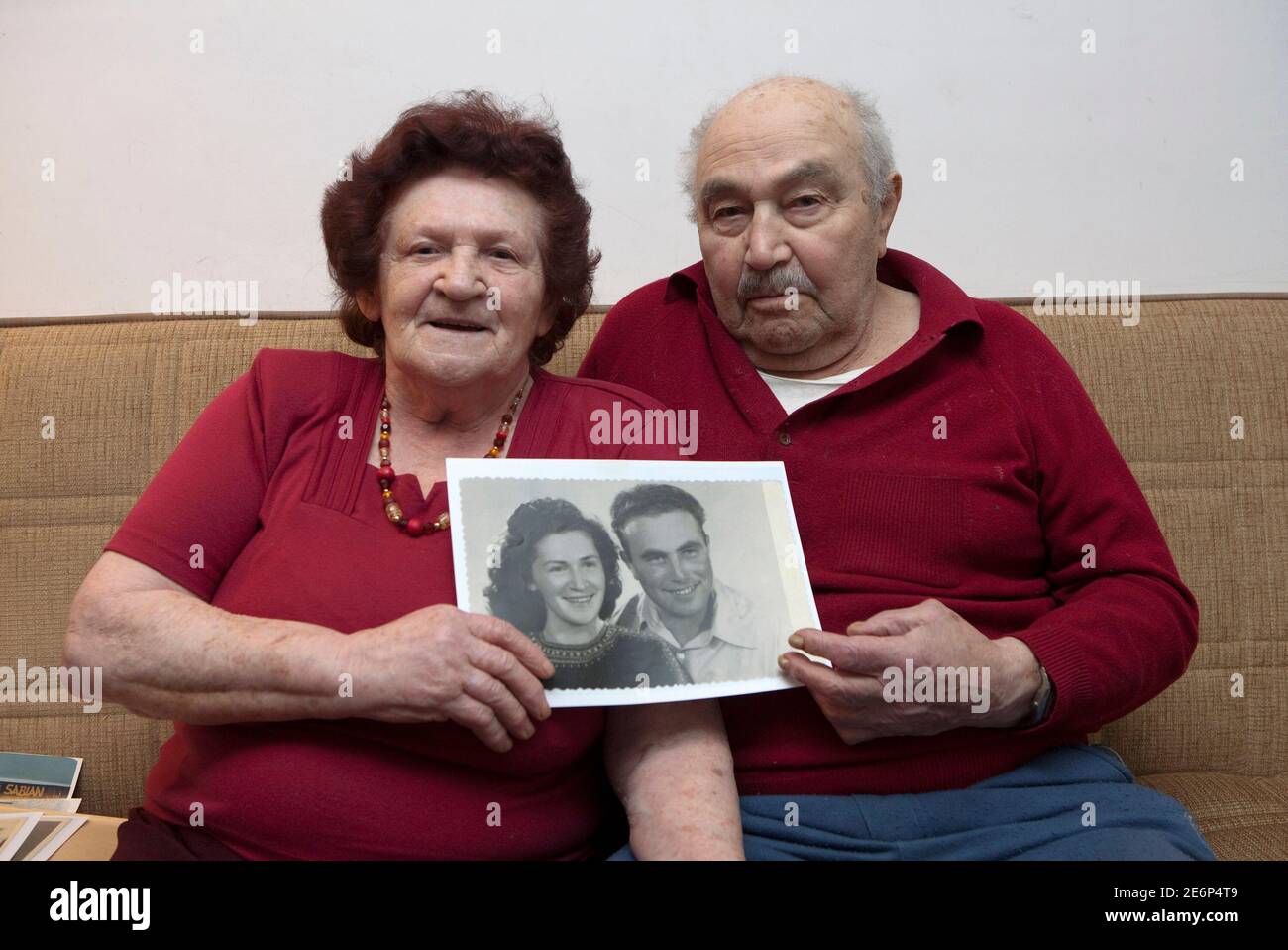 Holocaust survivors Silvia and Eliezer Harnik, both Romanian born, hold a picture of themselves when they were younger, at their home in Kibbutz Shaar Haamakim in northern Israel April 9, 2010.  The couple wed in British-ruled Palestine and currently have four children, 13 grandchildren and three great grandchildren. Picture taken April 9, 2010. Starting Sunday evening, Israel marks the annual memorial day commemorating the six million Jews killed by the Nazis in the Holocaust during World War Two.   REUTERS/Baz Ratner (ISRAEL - Tags: ANNIVERSARY CONFLICT) Stock Photo