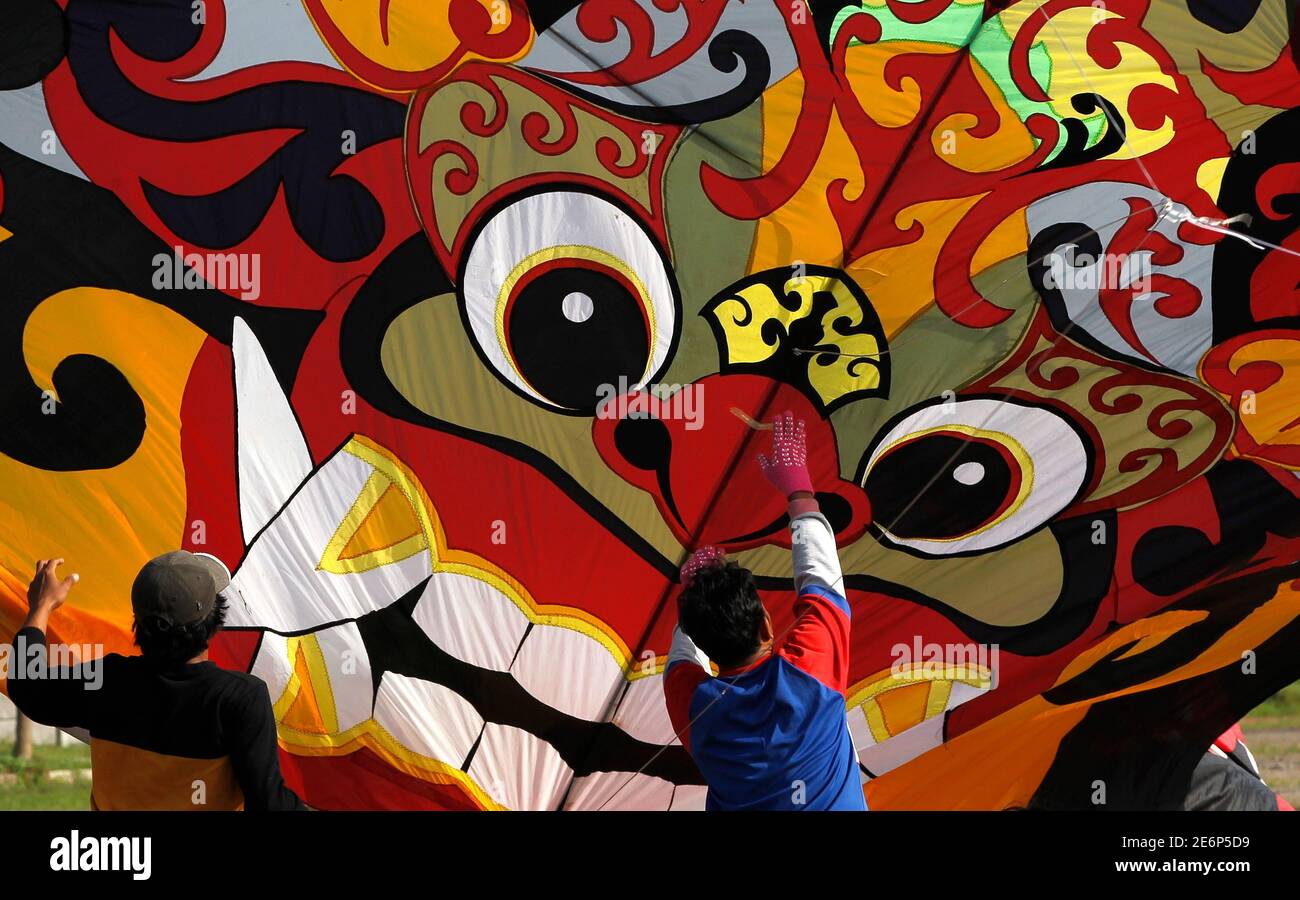 Indonesian participants prepare to fly a kite which resembles a Balinese shadow puppet during the Jakarta International Kite Festival July 24, 2010. Participants from 15 provinces in Indonesia and nine countries, including Australia, Germany, Malaysia, Singapore, the Netherlands and Japan, joined the two-day festival. REUTERS/Supri (INDONESIA - Tags: SOCIETY) Stock Photo
