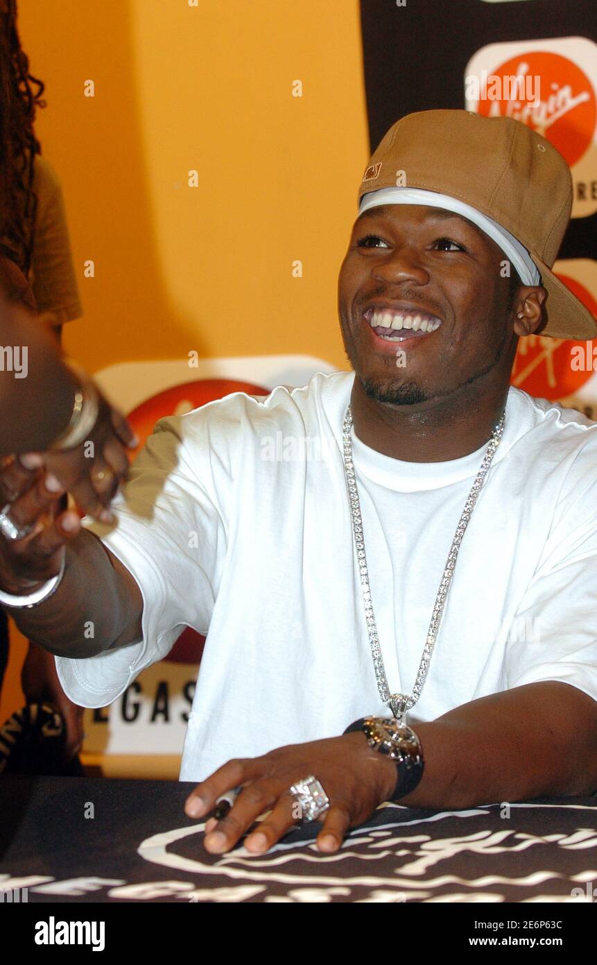 Rapper 50 Cent hands with a fan as signs copies of his book "From Pieces to Weight:Once Upon A Time in Queens" during a book signing at the Virgin