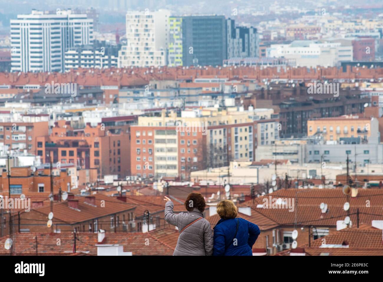 Madrid, Spain. 29th Jan, 2021. A couple of women look at a residential area in Madrid. One out of three households in the city of Madrid have been impoverished over 2020 due to the coronavirus (COVID-19) crisis, according to a report on the impact of the pandemic on the well-being of the families of Madrid presented today by the vice mayor, Begoña Villacis, with the delegate of Families, Equality and Social Welfare, Pepe Aniorte. Credit: Marcos del Mazo/Alamy Live News Stock Photo