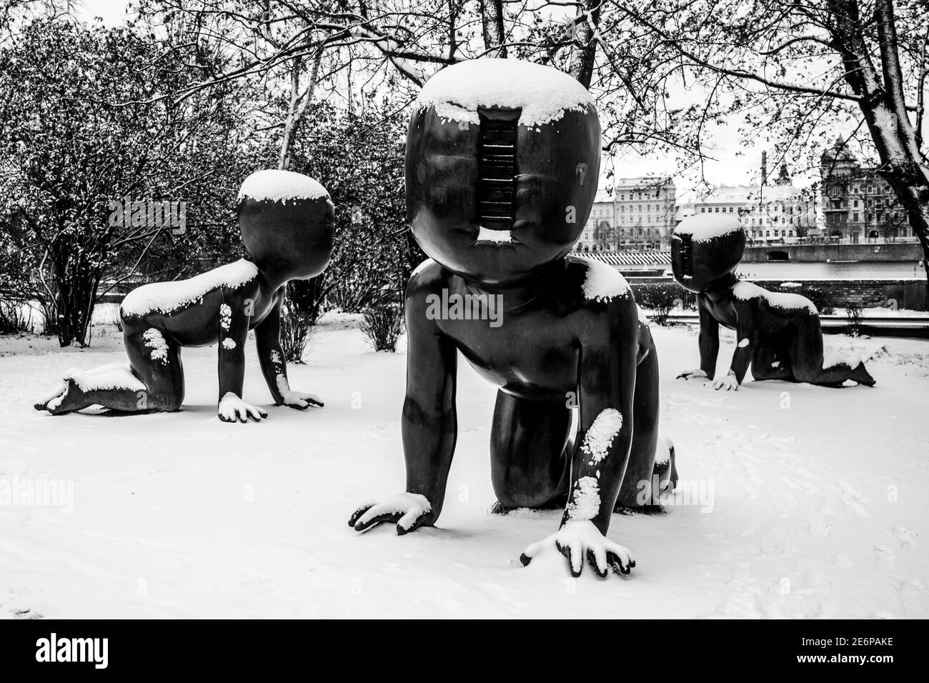 PRAGUE, CZECH REPUBLIC - JANUARY 14, 2021: Babies - Bronze scupltures installed on Kampa Island in Prague, Czech Republic. Artist: David Cerny. Sculptures covered by snow in winter. Black and white image. Stock Photo
