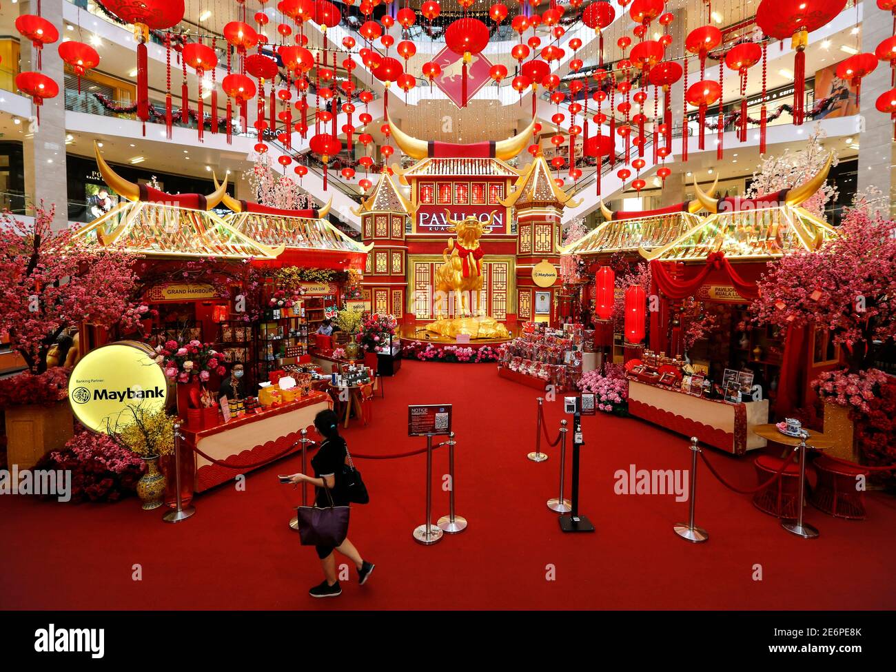 A shopper walks past the Chinese New Year decorations at an empty mall.Malaysia has recorded 5,725 new Covid-19 infections cases with sixteen fatalities in the past 24 hours. For the first time the number of infections has surpassed the 5,000 mark, which has brought the nation’s total number of infected individuals to 203,933. Stock Photo