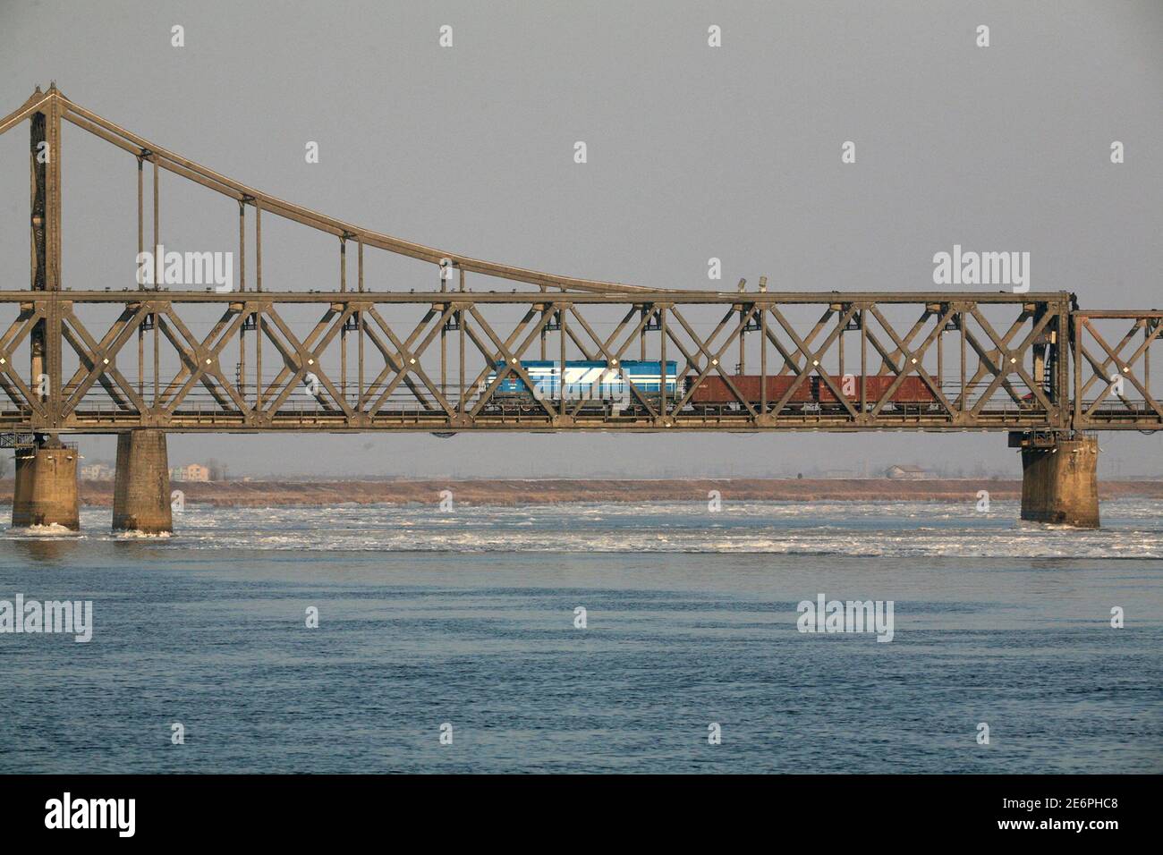 A freight train is seen on the Friendship Bridge over the Yalu River which connects the Chinese city of Dandong with Sinuiju in North Korea January 8, 2010. North Korea on Tuesday shut a customs house in the northwest part of the country near the Chinese border city of Dandong, closing the region, and sent police to reinforce the rail link, Japan's Nihon Keizai newspaper reported, indicating leader Kim Jong-il may be about to visit his neighbour and biggest benefactor, a report said on Wednesday.    REUTERS/Jacky Chen (NORTH KOREA - Tags: POLITICS MILITARY) Stock Photo