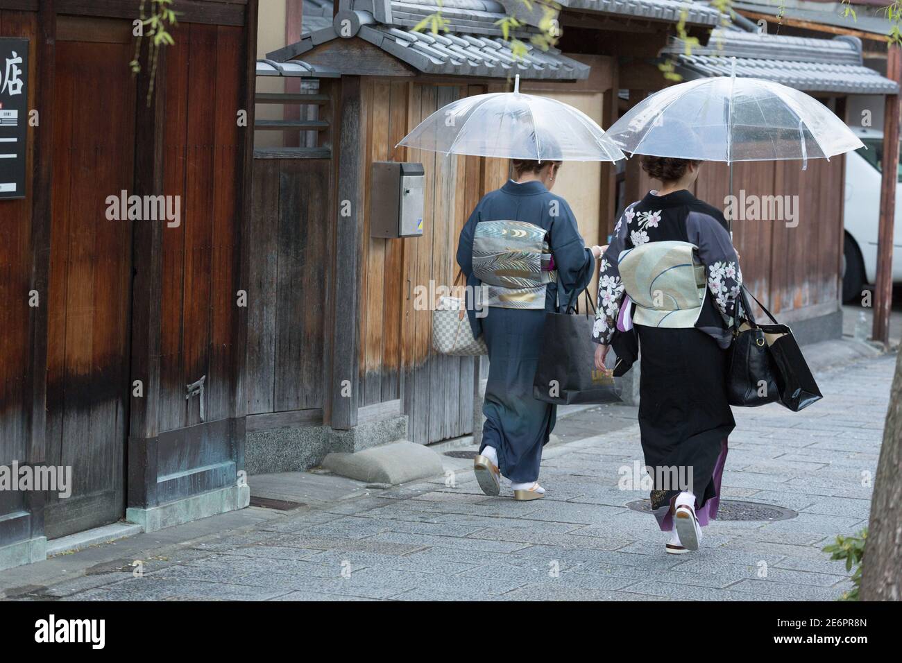 Women dressed as geisha walk through Gion District Stock Photo