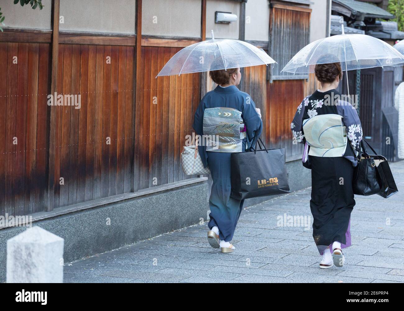 Women dressed as geisha walk through Gion District Stock Photo