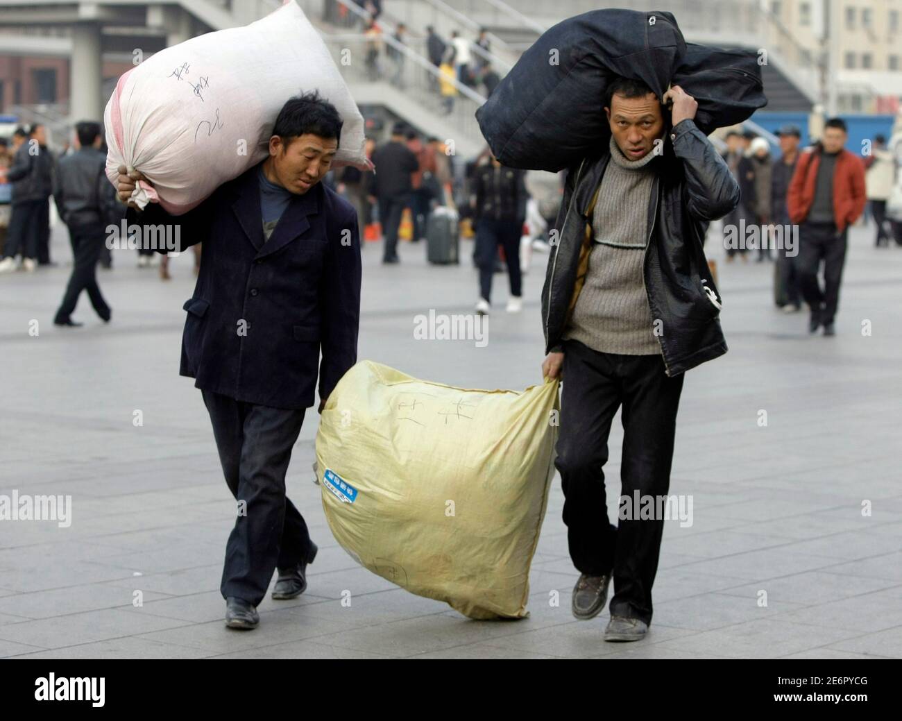 Migrant workers carry their bags as they leave Beijing Railway Station December 9, 2008. China's job market will weaken to a two-year low in the first quarter of 2009 as the global financial crisis takes its toll, Manpower Inc said in a survey released on Tuesday. REUTERS/Jason Lee (CHINA) Stock Photo