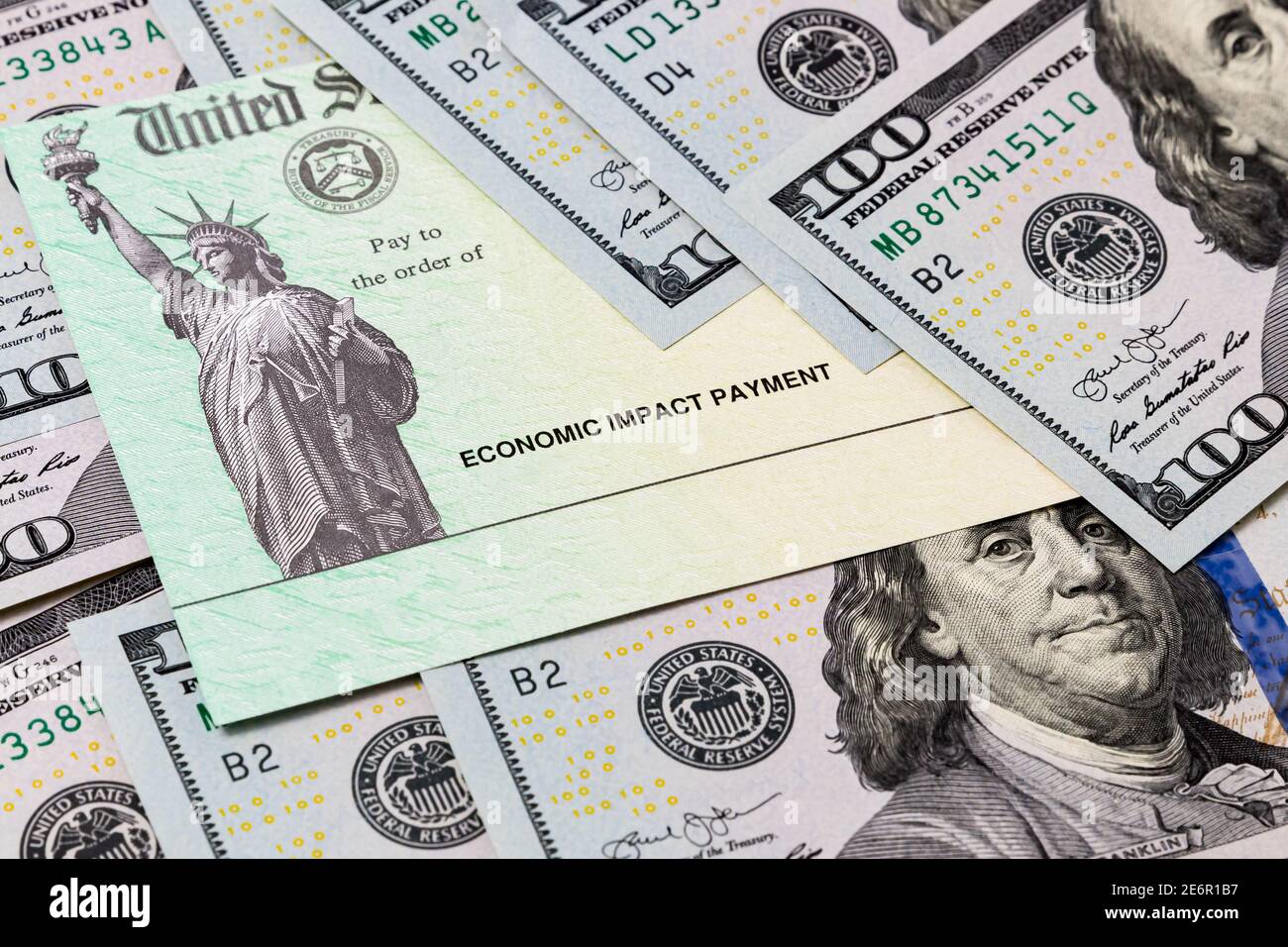 Economic impact stimulus treasury check and 100 dollar bills. Concept of aid, relief and unemployment insurance payment during Covid-19 coronavirus pa Stock Photo