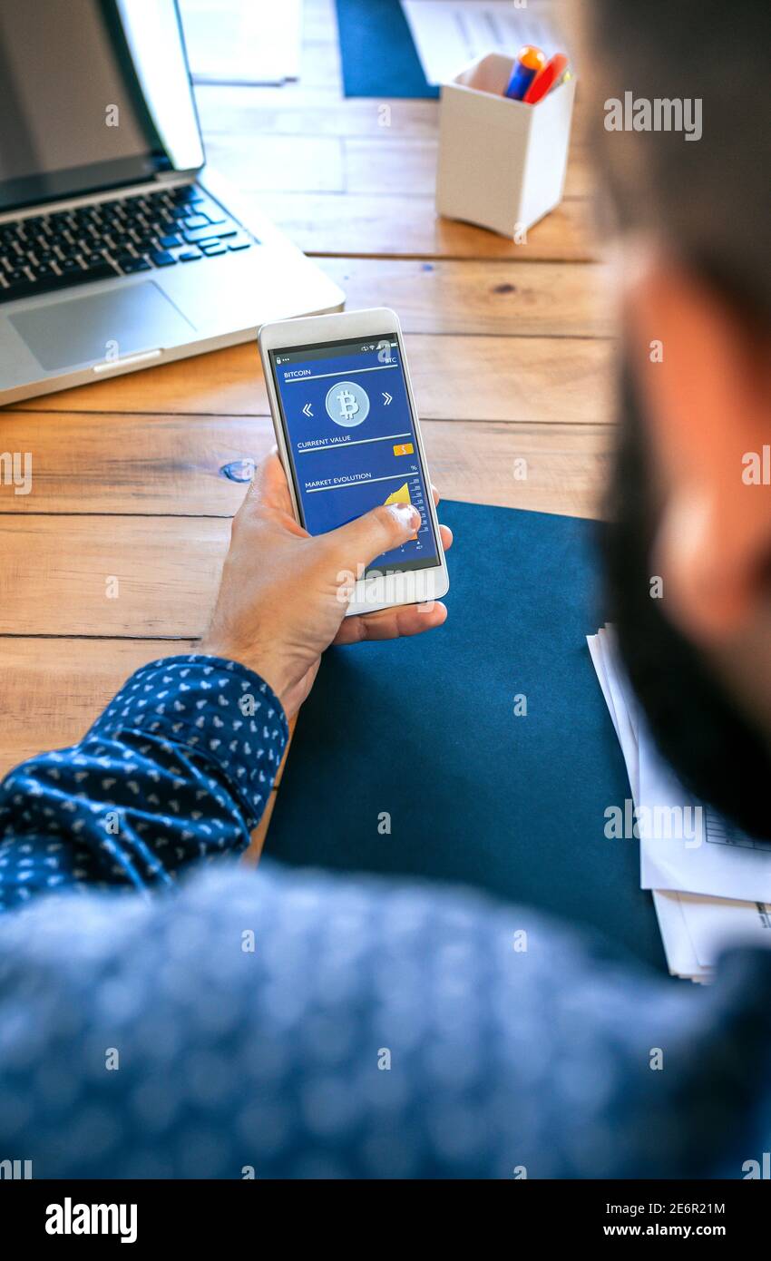 Businessman looking mobile with bitcoins information Stock Photo