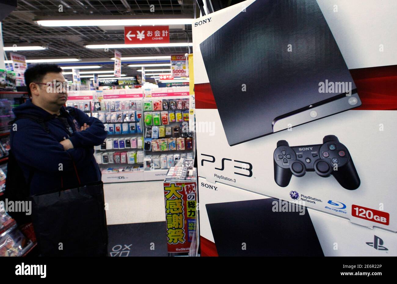 man looks at Sony's PlayStation 3 game consoles at an electronic store in Tokyo October 30, 2009. Sony Corp and Panasonic Corp signalled the may be for the world's