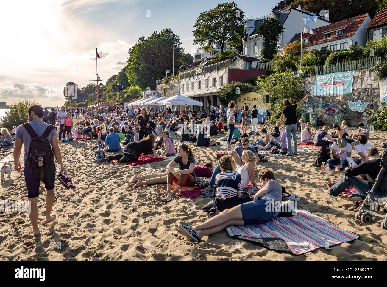 Locals and tourists relaxing in the sun on the sandy Elbstrand beach on ...