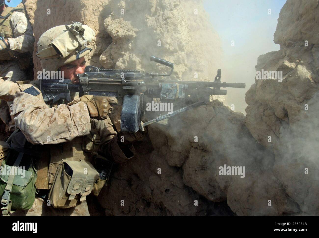 A U.S. Marine from Bravo Company of the 1st Battalion, 6th Marines fires his weapon at Taliban fighters in Marjah in Helmand province, southern Afghanistan, February 22, 2010.   REUTERS/Goran Tomasevic  (AFGHANISTAN - Tags: CIVIL UNREST POLITICS) Stock Photo