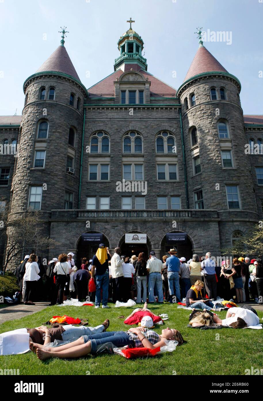 People lie on the ground outside St. Joseph's Seminary at a rally for Pope Benedict XVI in Yonkers, New York April 19, 2008.     REUTERS/Lucas Jackson (UNITED STATES) Stock Photo