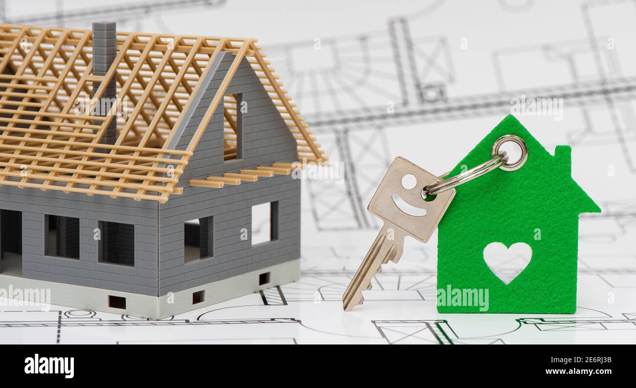 model home standing on construction plan and house key Stock Photo