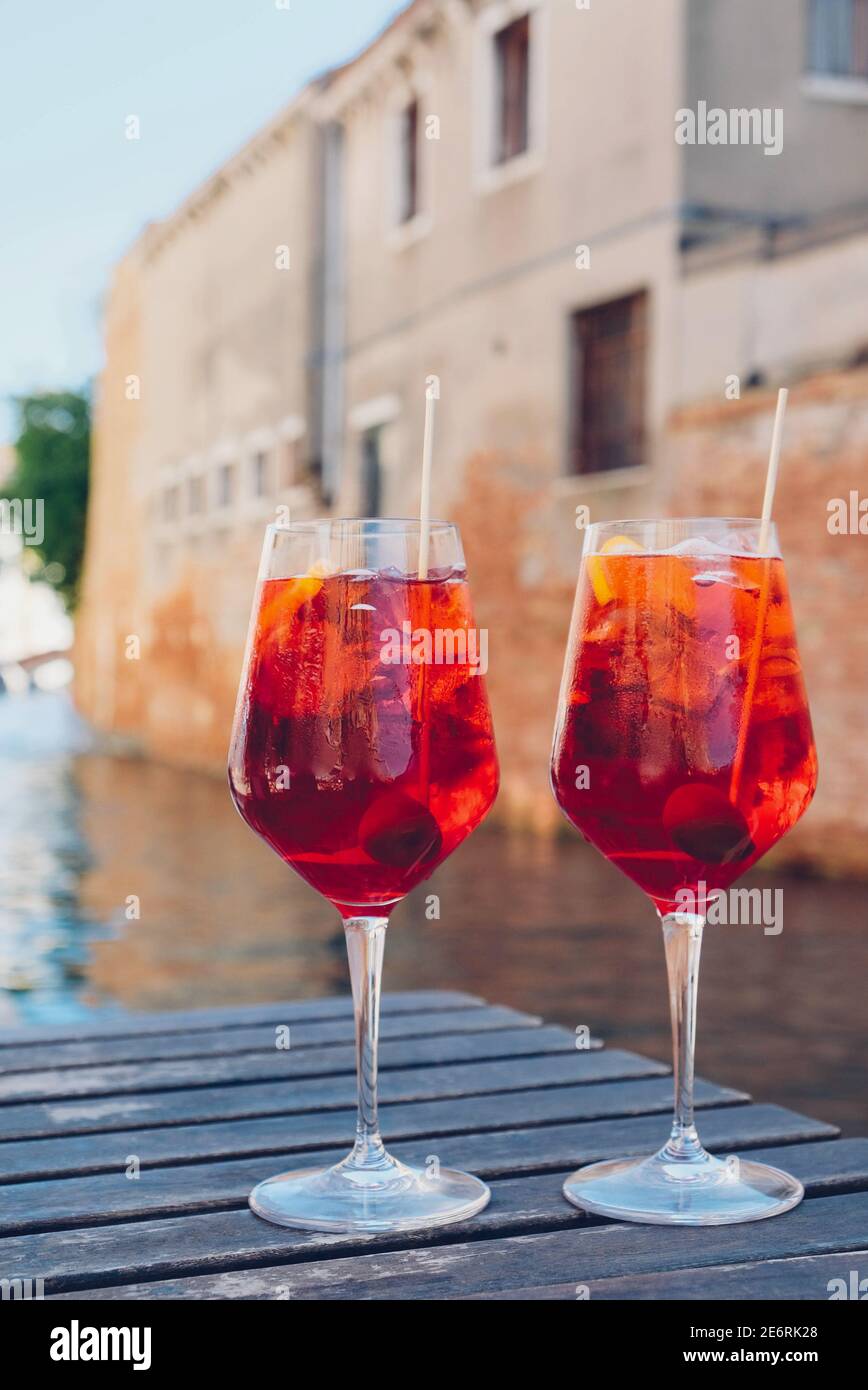 Two glasses of Spritz Veneziano cocktail served near the Venetian canal. Popular italian summer aperitif drink. Venice background. Stock Photo