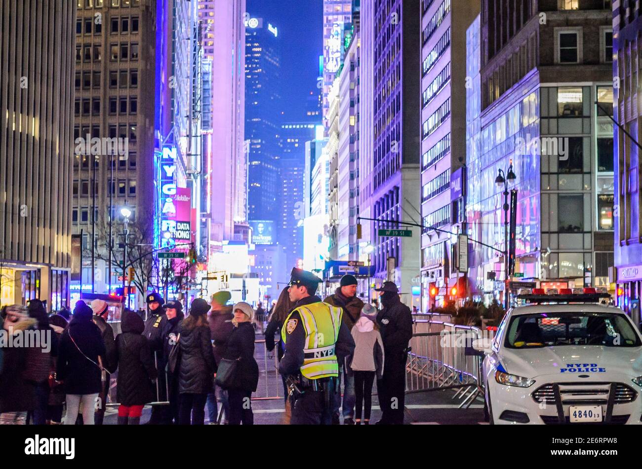 Police Officer Patroling and NYPD Vehicle Parked in Times Square Blocking The Way for New Years Eve Celebrations. Manhattan, New York City, USA Stock Photo