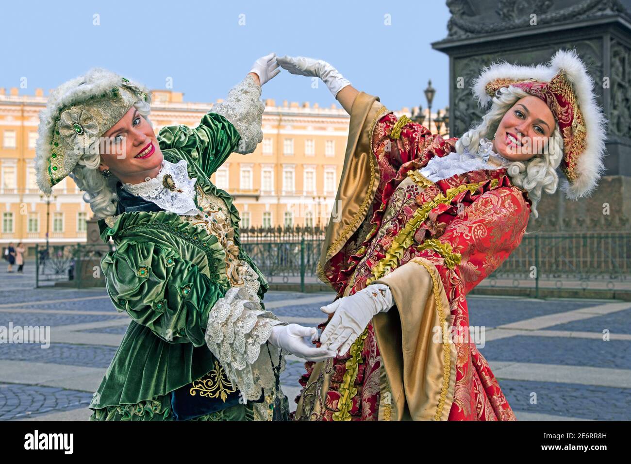 Two Russian women in 18th century period dresses posing for tourists by the Hermitage Winter Palace on Palace Square in the city St Petersburg, Russia Stock Photo