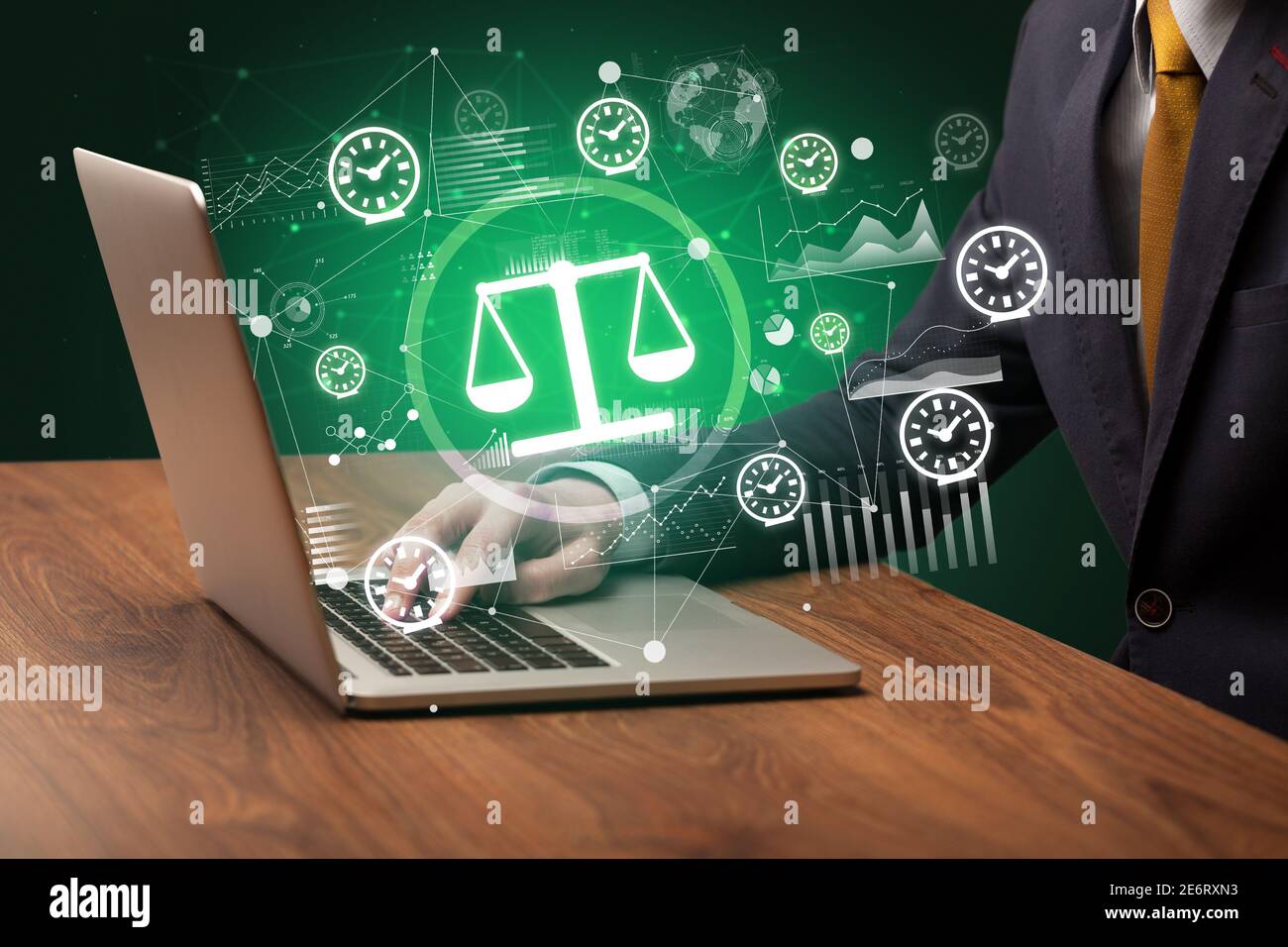 Business hand working on laptop with balance icons coming out from the ...