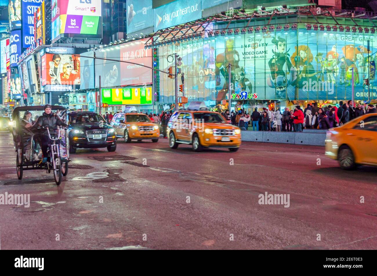 Times Square in Midtown Manhattan at Night. Traffic on the Road and Toys R Us Store in