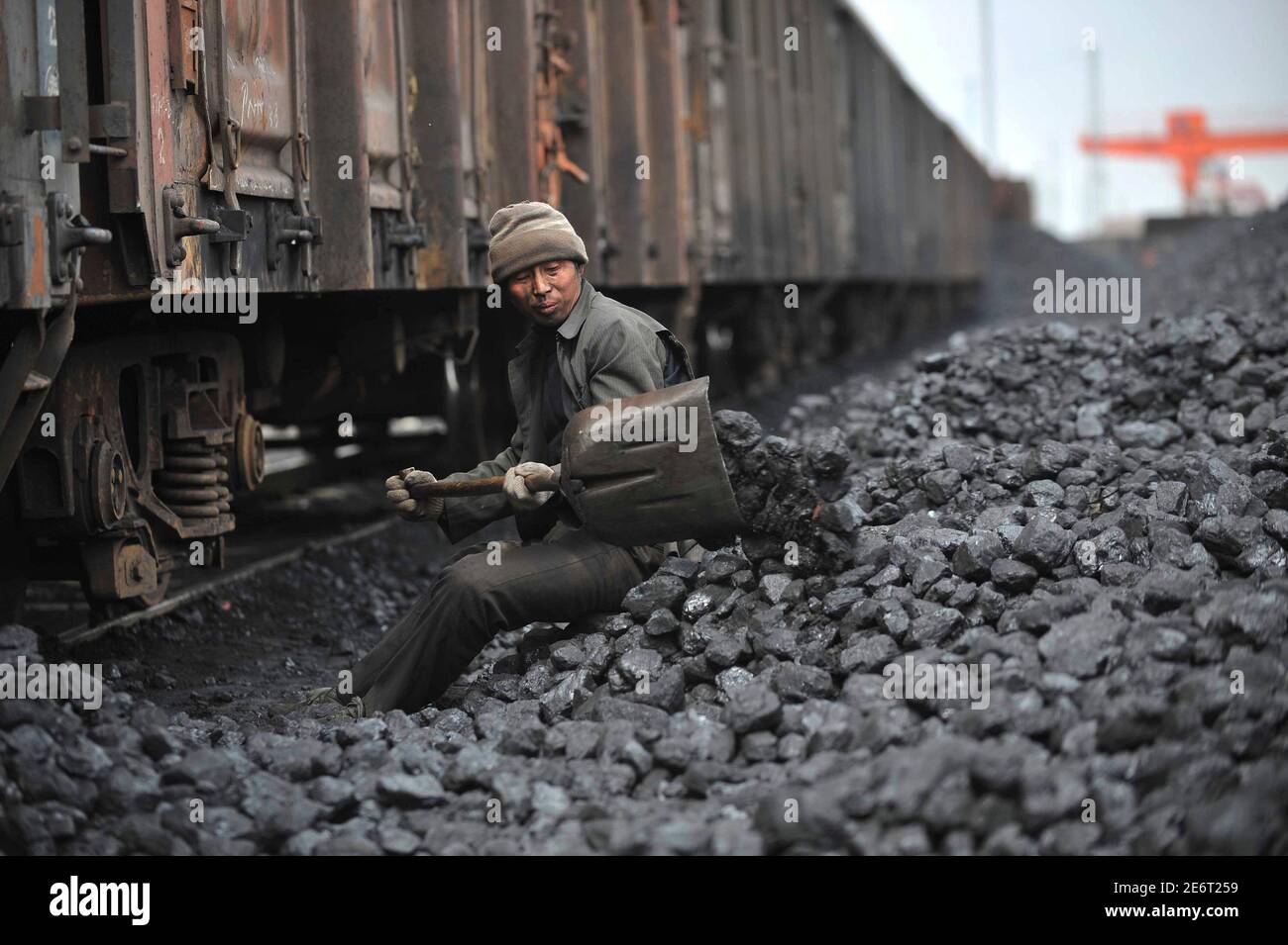 A worker unloads coal at a storage site along a railway station in Shenyang, Liaoning province April 13, 2010. China's coal imports this year will remain at similar levels to last year, when they rose to a record high on strong Chinese demand and weak international prices, Fang Junshi, director-general of the Department of Coal Industry at China's National Energy Administration, said on Monday. REUTERS/Sheng Li (CHINA - Tags: ENERGY EMPLOYMENT BUSINESS) Stock Photo