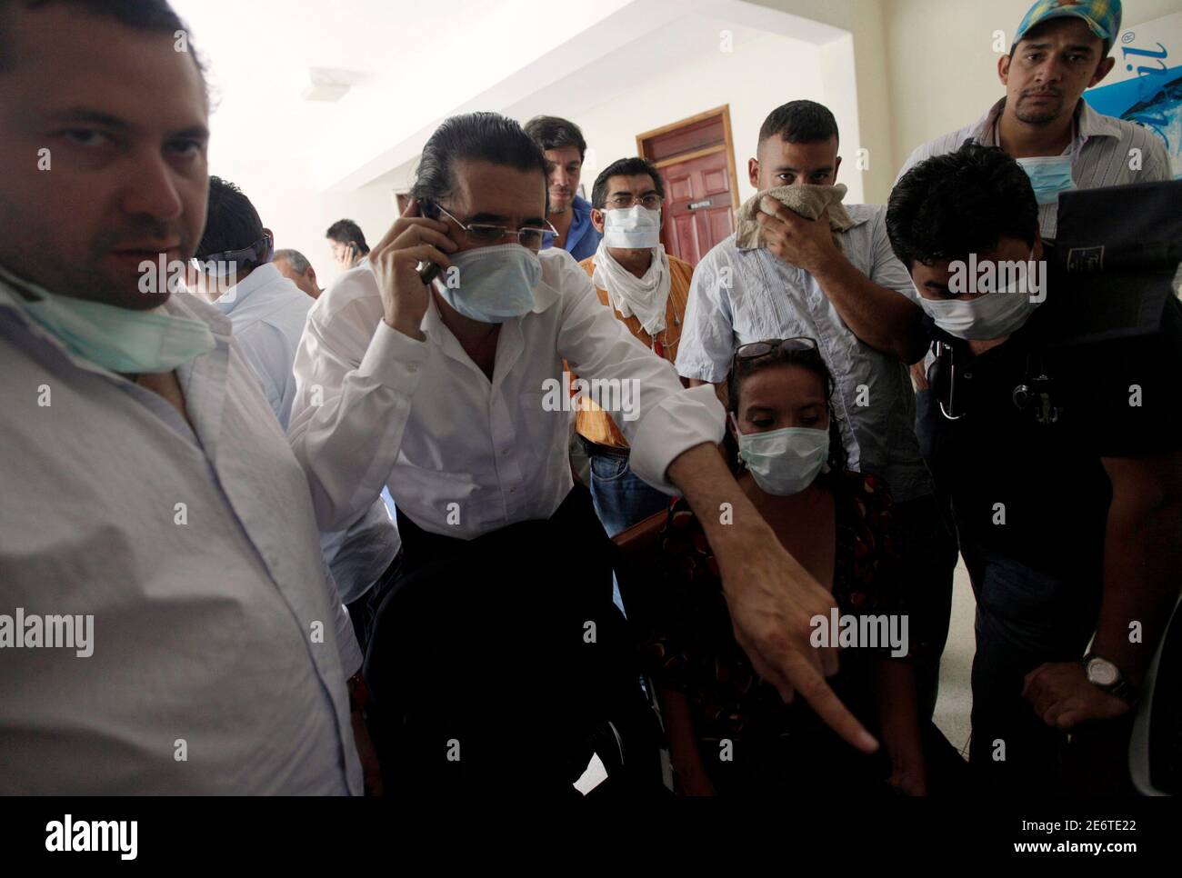 Honduras' ousted President Manuel Zelaya (2nd L) and his wife Xiomara Castro (2nd R) look at a computer while wearing surgical masks in the Brazilian embassy in Tegucigalpa September 25, 2009. Zelaya, who is sheltering in the embassy after slipping back into the country on Monday, accused the de facto government of injecting 'toxic gas' into the building during a news conference given to journalists still inside the building. Many inside the embassy complained of burning throats, while others showed the presence what seemed to be trace of blood in their saliva.  REUTERS/Edgard Garrido (HONDURA Stock Photo