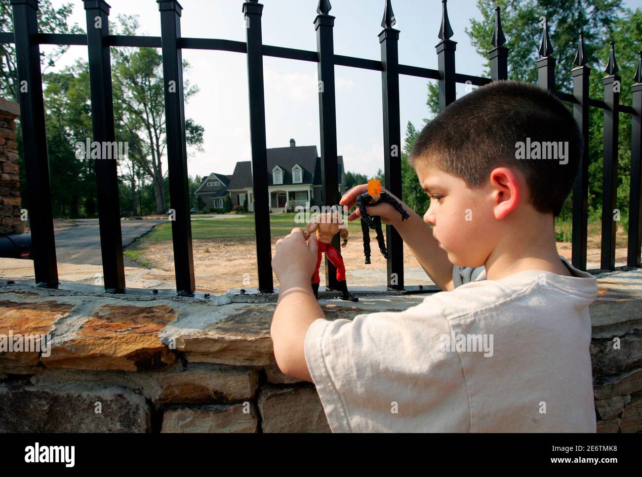 Chase Sullivan, 7, places his wrestler action figure on the wall outside  the home of professional wrestling superstar Chris Benoit in Fayetteville,  Georgia, June 26, 2007. Benoit was found dead along with