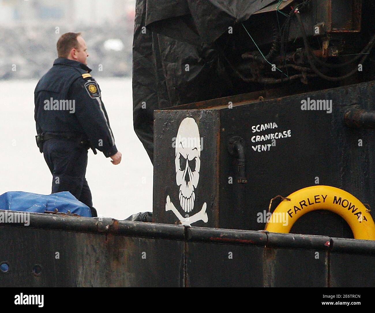 A Canadian federal official walks past a skull and crossbones sign painted on the Sea Shepherd Conservation Society vessel Farley Mowat, shortly after it was brought into Sydney, Nova Scotia, April 13, 2008. The Canadian government boarded Farley Mowat and charged the ship's Captain and first mate for alleged violations during the east coast seal hunt.  REUTERS/Paul Darrow  (CANADA) Stock Photo
