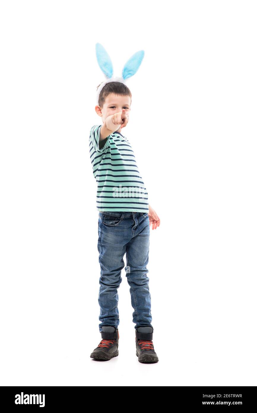Cool confident young cute boy with Easter bunny ears pointing finger at camera pick you. Full length isolated on white background. Stock Photo