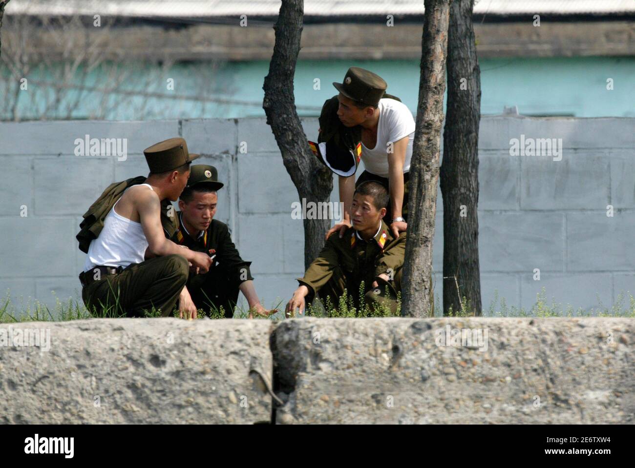 North Korean soldiers chat on the banks of the Yalu River near the North Korean town of Sinuiju, opposite the Chinese border city of Dandong, May 27, 2009.  North Korea on Wednesday threatened a military strike against the South a day after Seoul joined a U.S.-led initiative to intercept shipments suspected of being involved in weapons of mass destruction. REUTERS/Jacky Chen (POLITICS MILITARY) Stock Photo