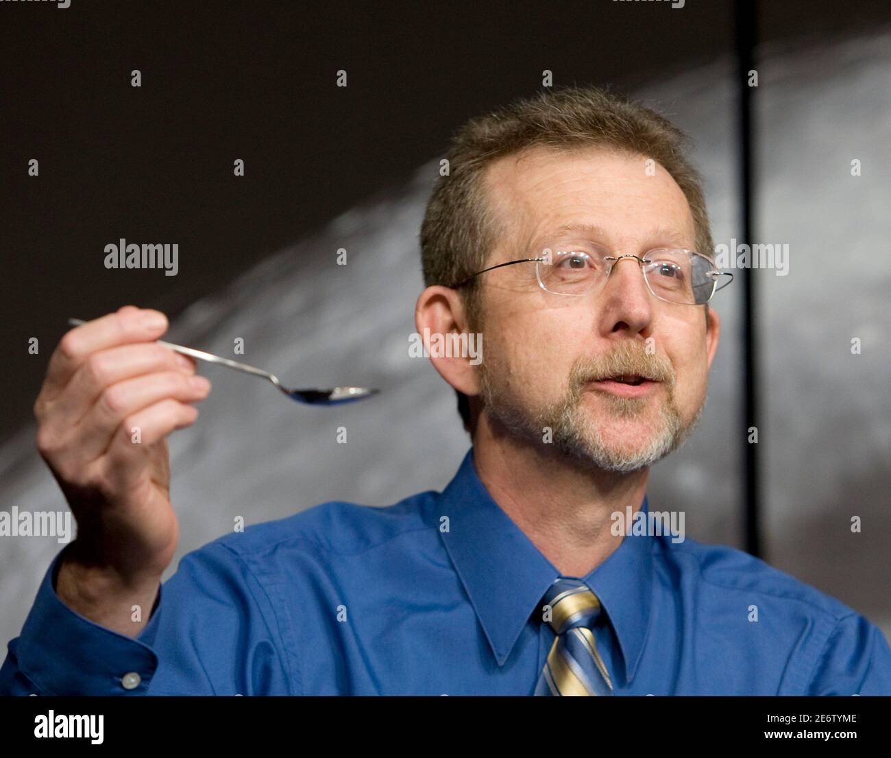 Director of Planetary Science Division in NASA's Science Mission Directorate Jim Green holds up a spoon to demonstrate how much water scientists thought to be on the moon during the NASA announcement of new science data about the presence of water on the moon collected during space missions in Washington September 24, 2009. Three separate missions examining the moon have found clear evidence of water there, apparently concentrated at the poles and possibly formed by the solar wind.  REUTERS/Larry Downing (UNITED STATES SCI TECH IMAGES OF THE DAY) Stock Photo