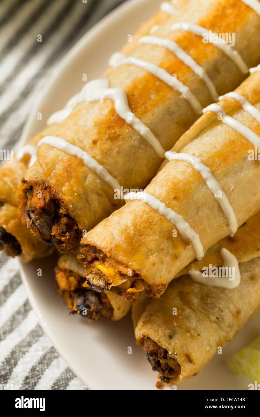 Homemade Mexican Chicken Flautas with Crema and Lettuce and Tomato