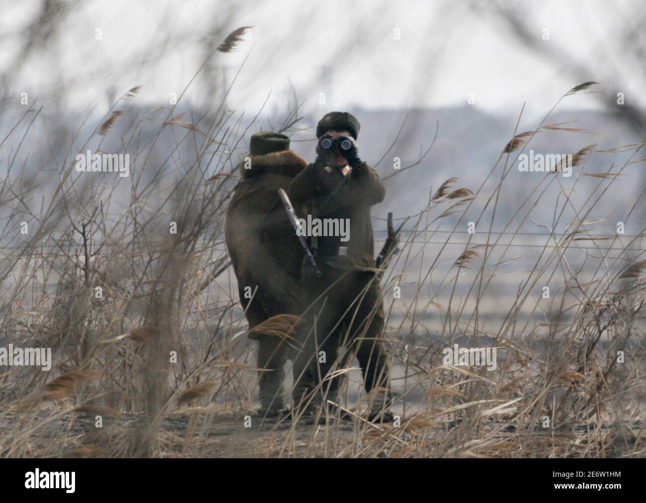 North Korean soldiers guard the banks of Yalu River near the North Korean town of Sinuiju, opposite the Chinese border city of Dandong February 25, 2010. North Korea's neighbours and the United States want fresh momentum in trying to restart talks about ending Pyongyang's nuclear arms programme, a U.S. envoy said, while giving no signs of an impending breakthrough. REUTERS/Jacky Chen (NORTH KOREA - Tags: POLITICS MILITARY) Stock Photo