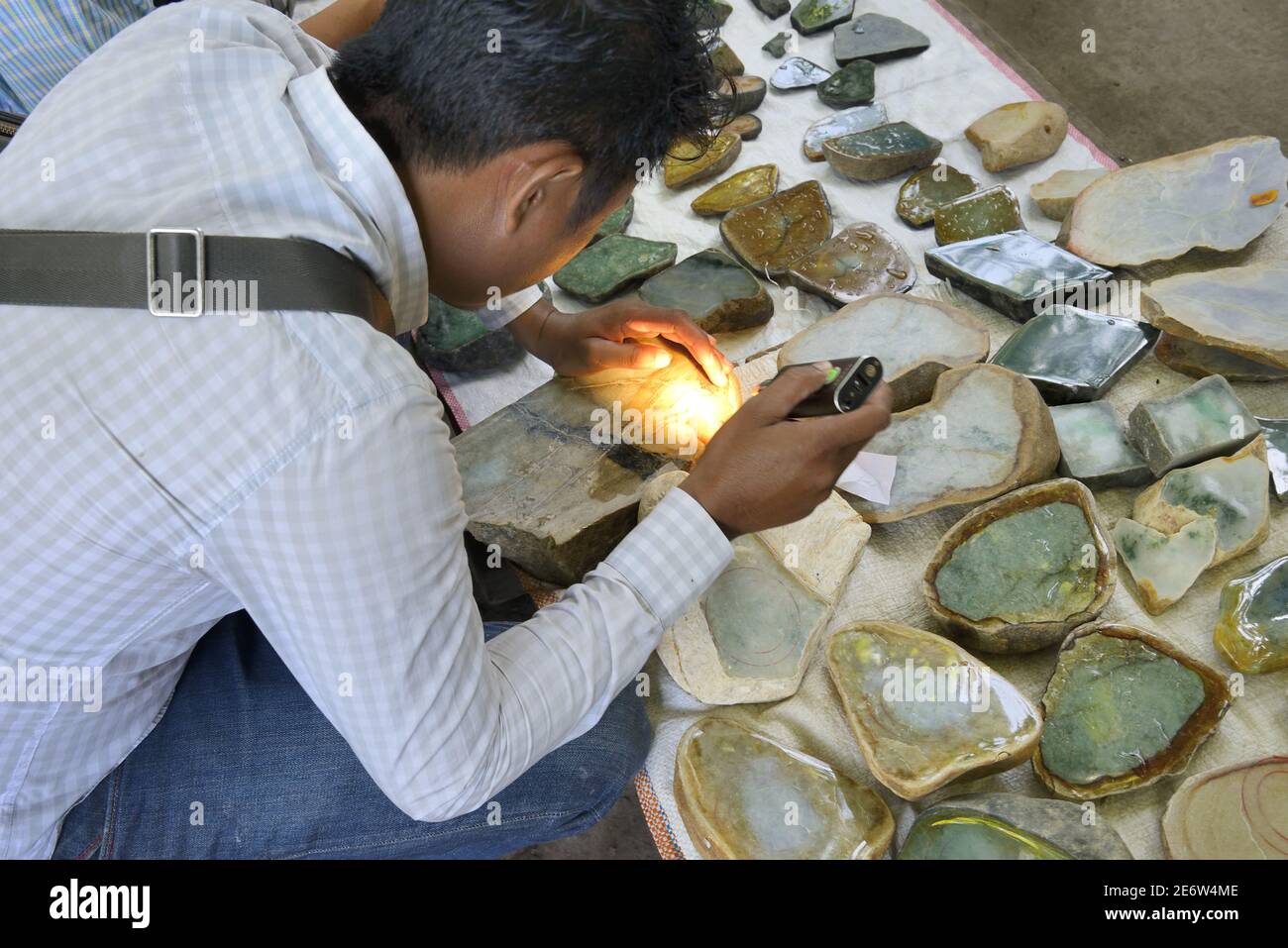 Myanmar (Burma), Mandalay, Jade market, Buyer examining a jade stone