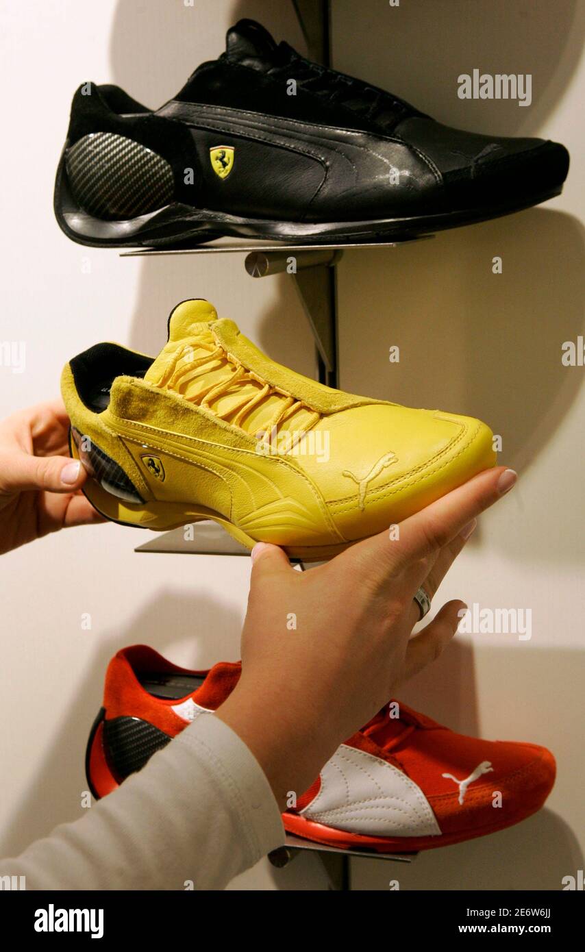 An employee tidies up shoes in the Puma factory outlet store in  Herzogenaurach near Nuremberg April 10, 2007. French retailer PPR on  Tuesday made a 5.3 billion euro ($7.07 billion) bid to