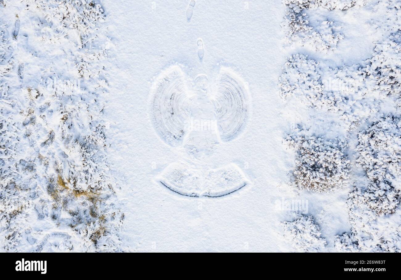 Magical Snow Angel photographed by drone, Scottish Highlands, UK. With footprints. Stock Photo