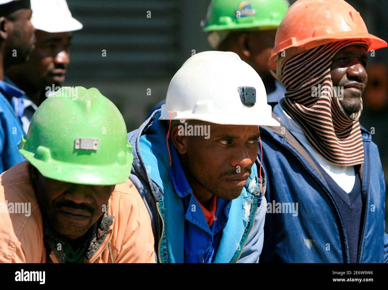 Rescued mine workers rest after emerging from the pithead at the Harmony Gold mine in Carletonville, west of Johannesburg, October 4, 2007. Some 850 miners remained trapped more than a mile underground in the South African gold shaft on Thursday after a day-long rescue effort. The last of the 3,200 stranded when the electricity cable of the mine's main lift was severed were expected to be lifted out by 1800 GMT, nearly 36 hours after the accident.  REUTERS/Juda Ngwenya (SOUTH AFRICA) Stock Photo